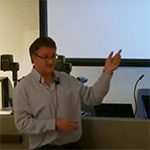 Man presenting in front of lecture theatre
