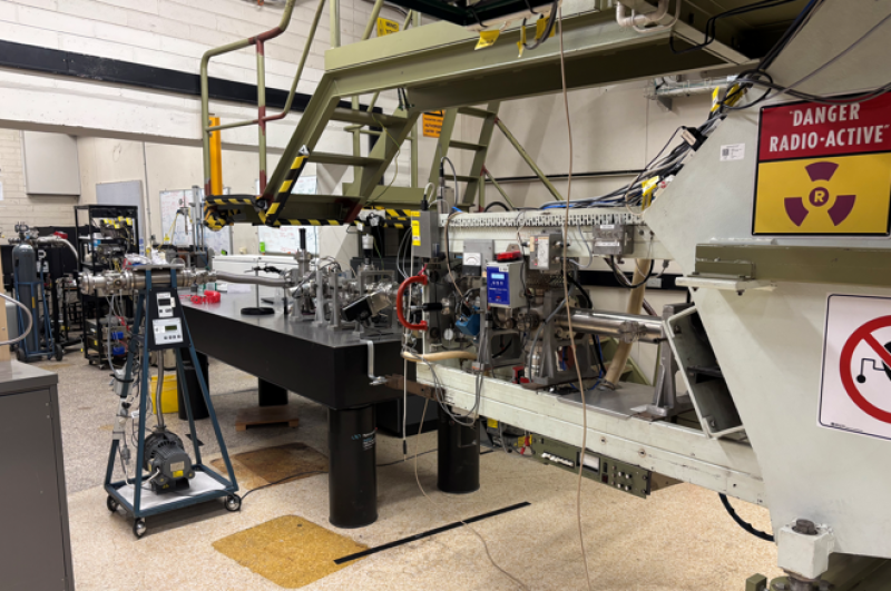 A side view of a particle accelerator, with a sign saying 'radioactive'